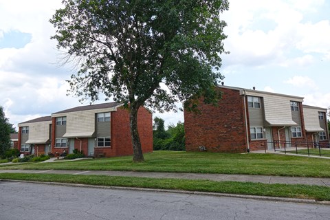 a row of apartment buildings on the side of a street