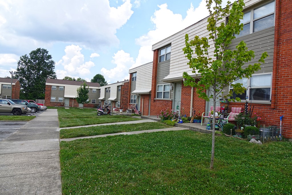 a row of houses with a sidewalk and grass