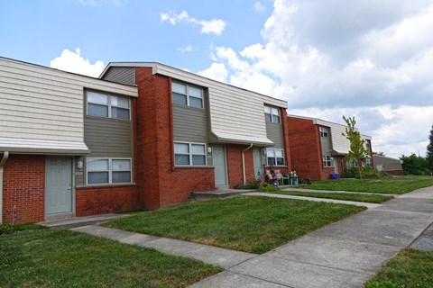 an apartment building with a sidewalk in front of it
