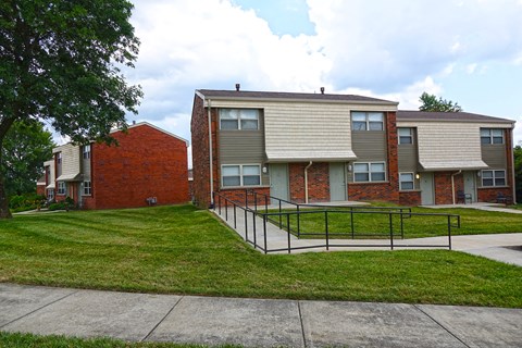 an apartment building with a fenced in yard and stairs