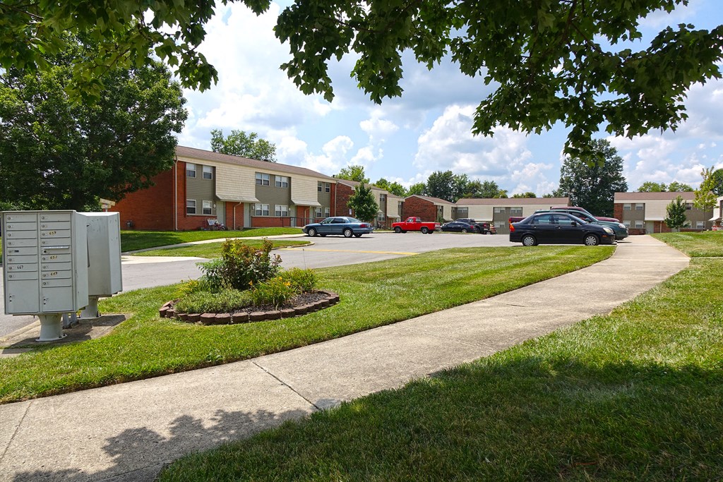a city street with cars parked in front of apartment buildings