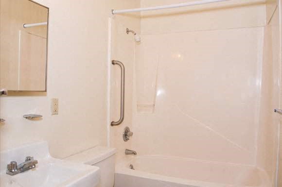 a white bathroom with a shower and a sink