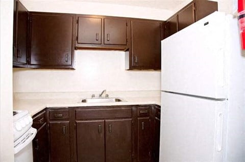 a kitchen with brown cabinets and a white refrigerator