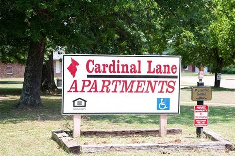 a white sign in the middle of a park