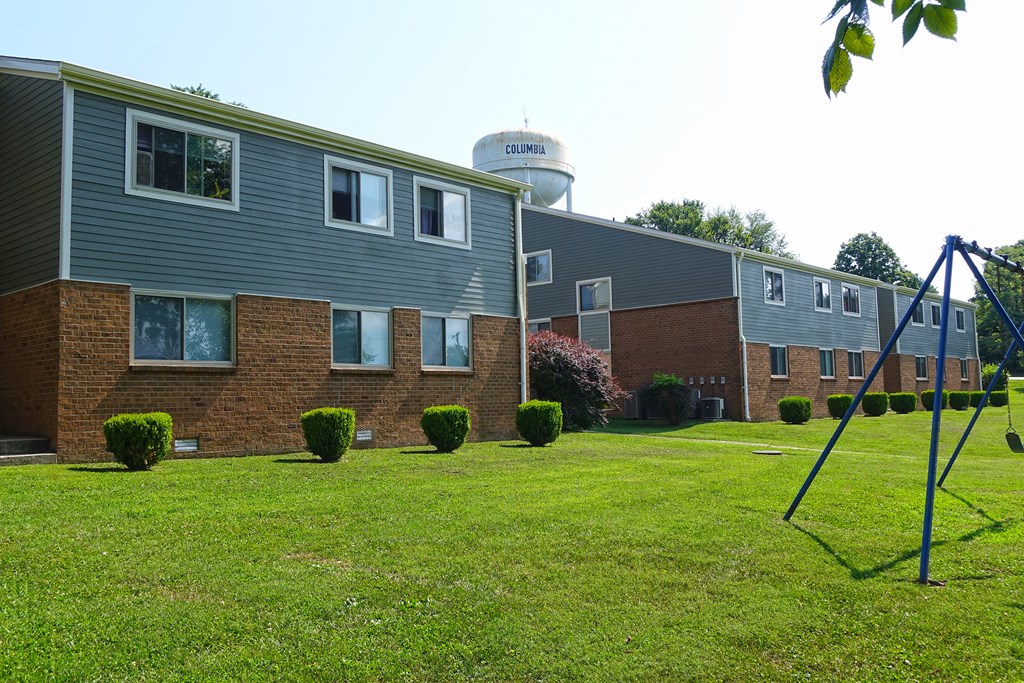 a yard in front of a building with a swing set