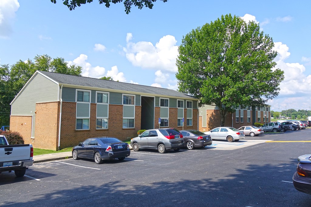 an apartment building with cars parked in a parking lot