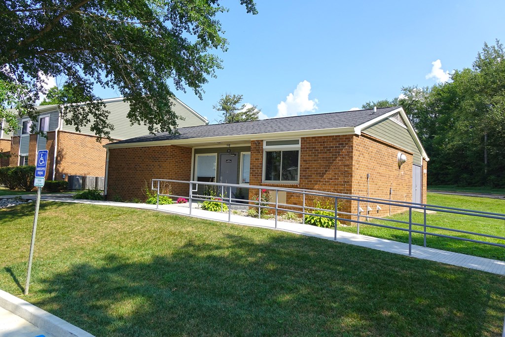 the front of a brick building with a lawn