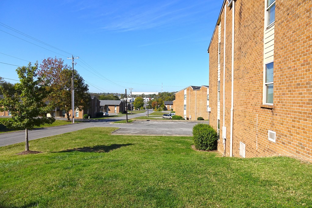 the side of a brick building with a green lawn