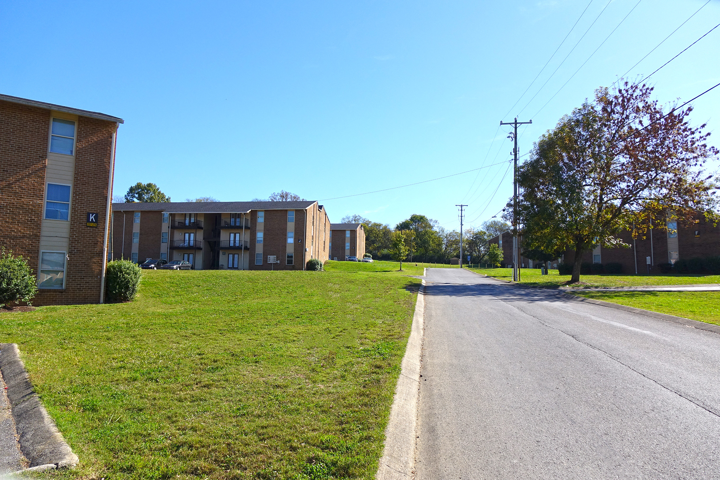 a row of brick apartment buildings on the side of a road