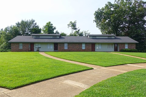 a house with a lawn and a sidewalk in front of it