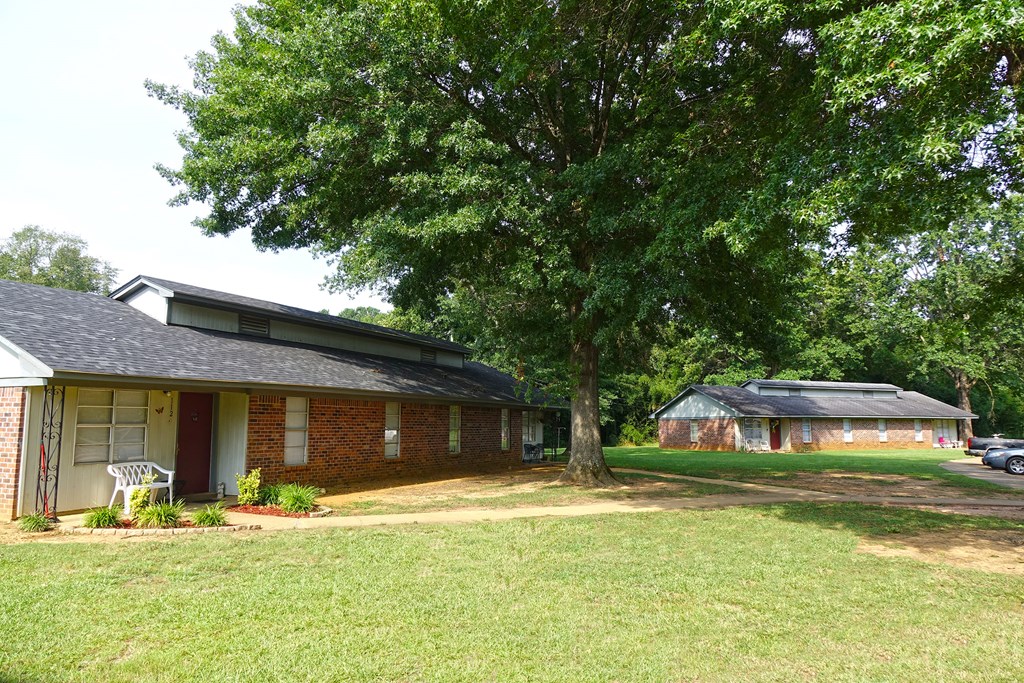 a brick house with a tree in the yard and a garage