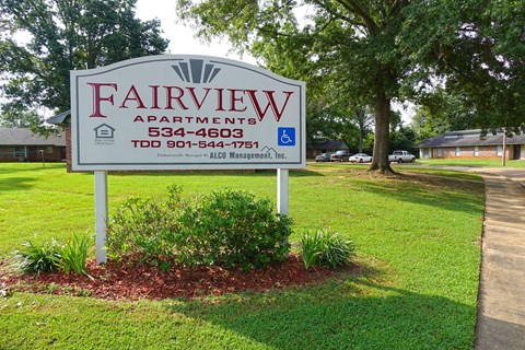 a sign for fairview apartments on the side of the street