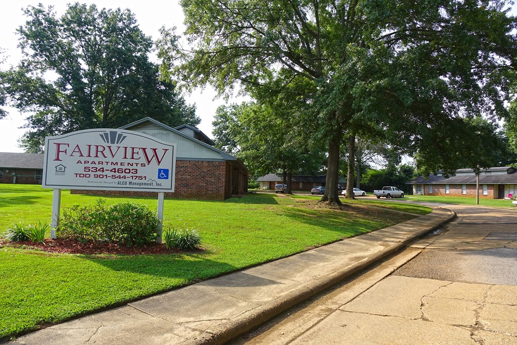 a sign for fairview apartments on the side of a street