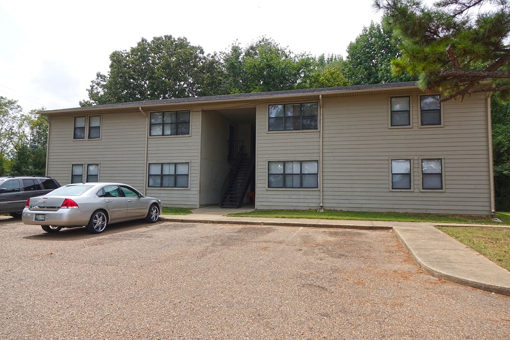 a large apartment building with cars parked in front of it