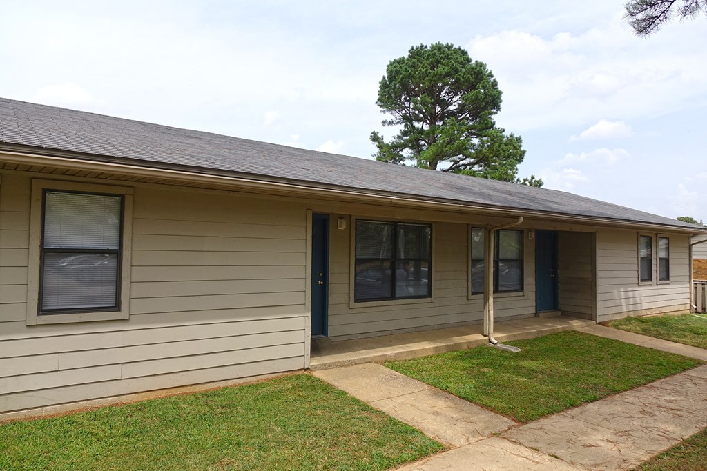 the front of a house with a yard and a tree