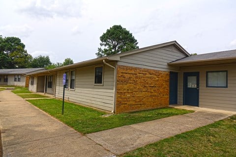 a white and brown building with a sidewalk and a blue door