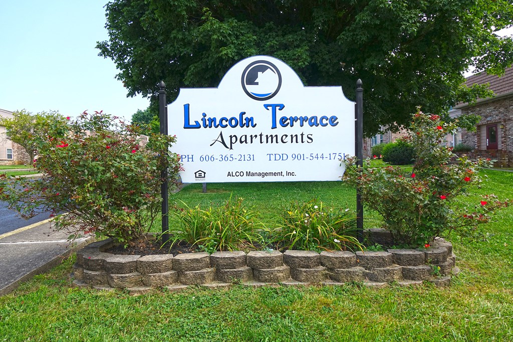 a sign terrace apartments in front of a garden