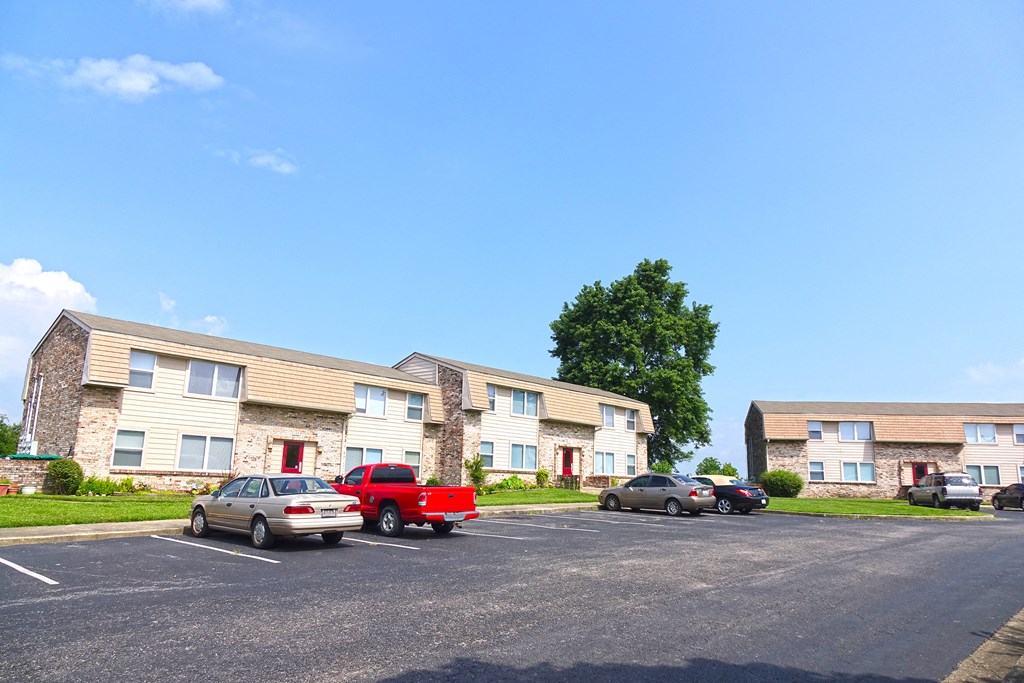 a parking lot with cars in front of apartment buildings