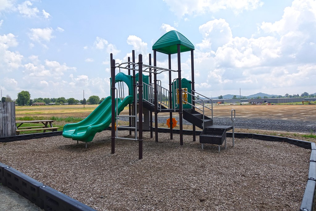 a playground with a slide and other toys in a field