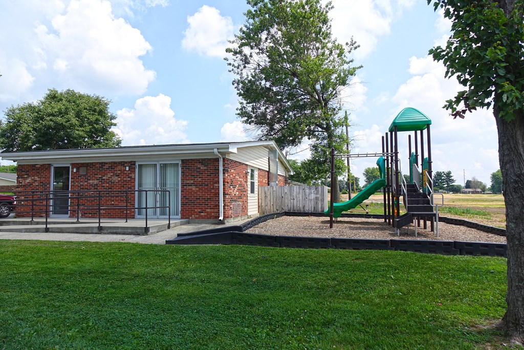 a playground in front of a building with a play set