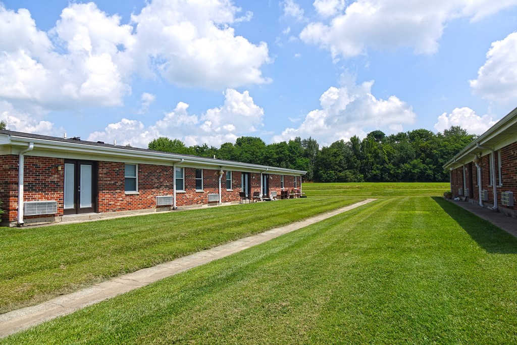 a row of barracks with a grassy field in front of them