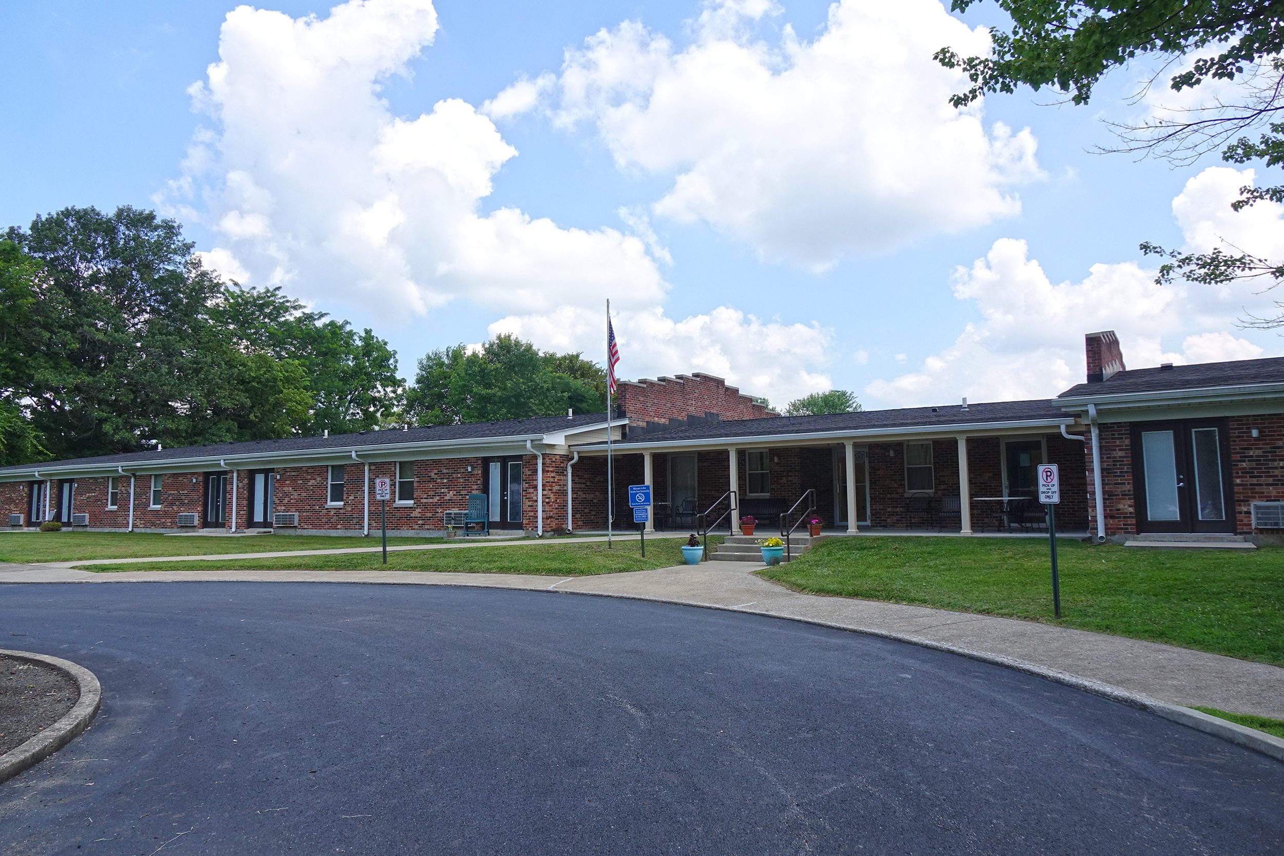 a view of the front of a red brick building with a driveway and a street