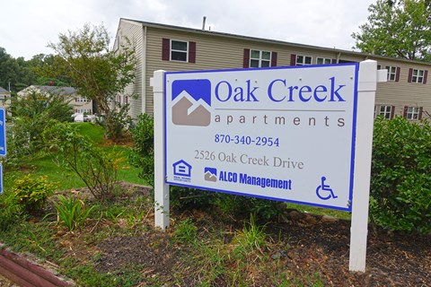 a sign apartments in front of a house
