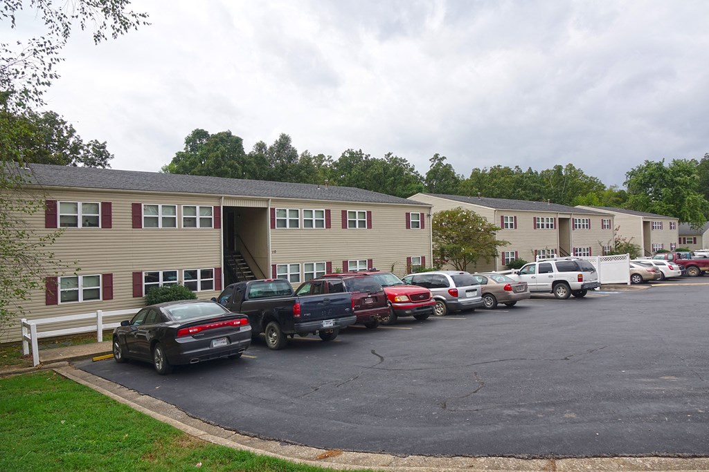 a parking lot full of cars in front of an apartment building