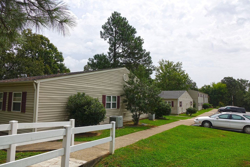 a white car parked in front of a gray house