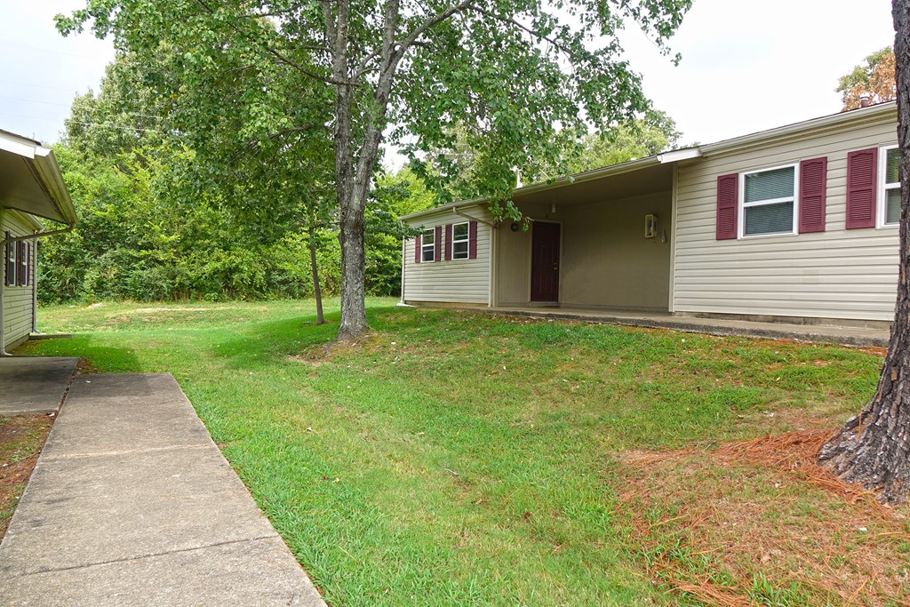 the front of a house with a yard and a sidewalk