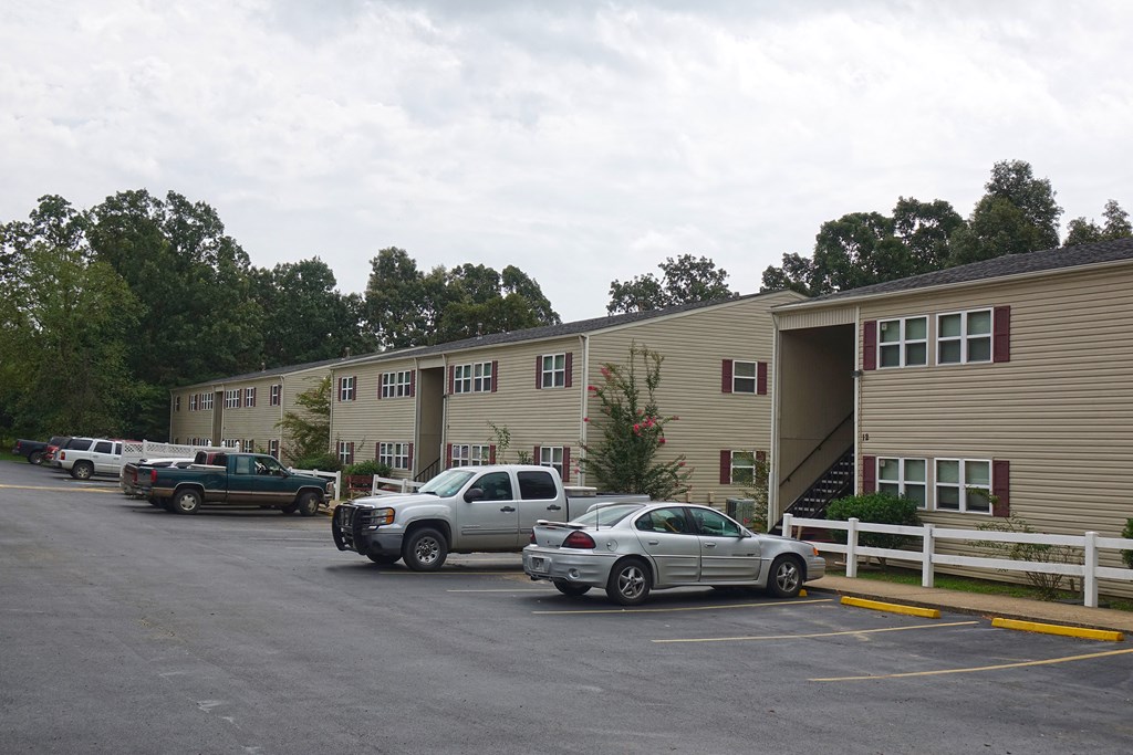 a parking lot with cars in front of an apartment building