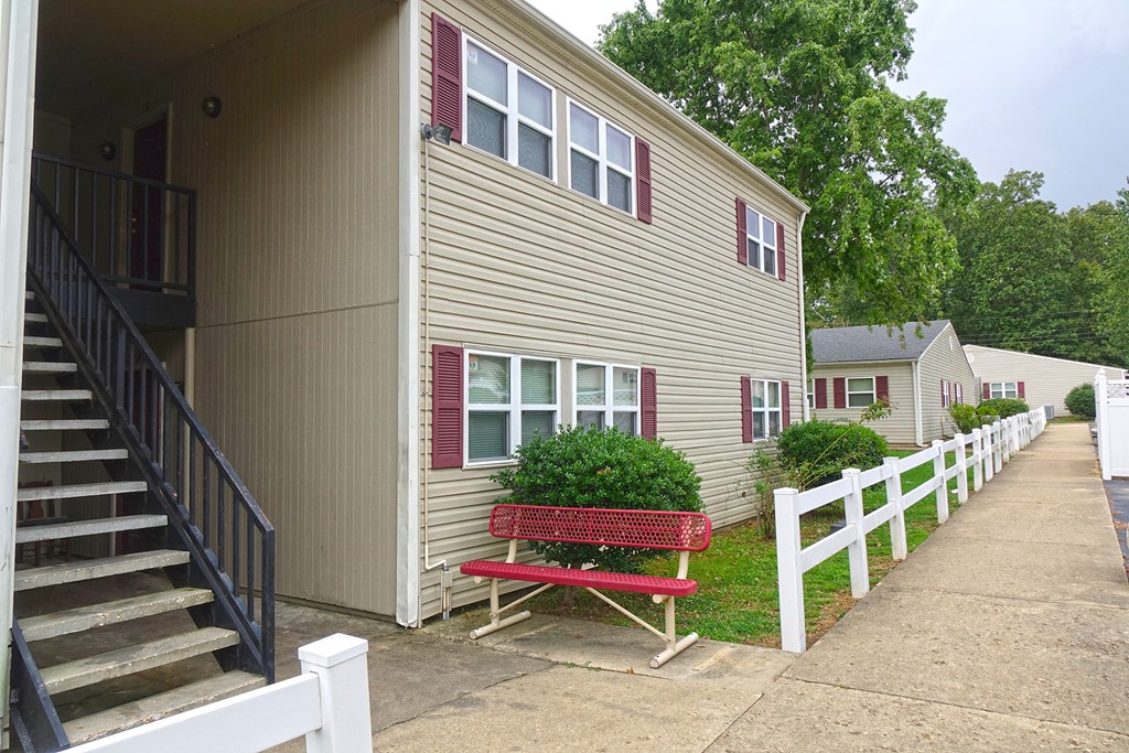 a red bench sits in front of a building
