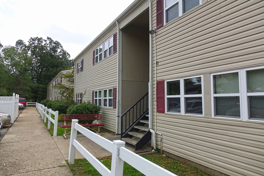 the side of a house with stairs and a sidewalk