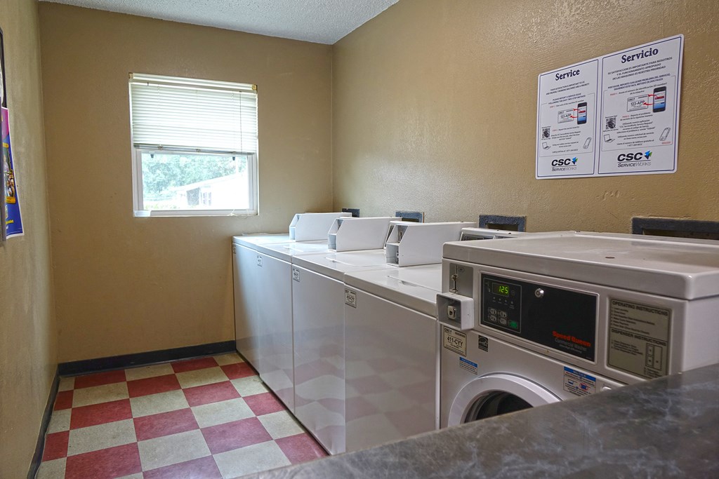 a laundry room with two washers and two washing machines