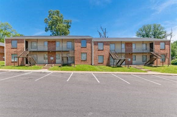 a brick apartment building with a parking lot