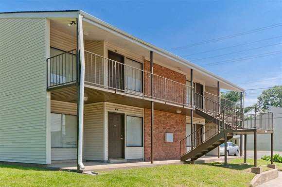 an apartment building with a balcony and a staircase