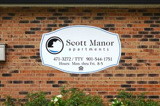 a sign on a brick wall that says scotch manor apartments