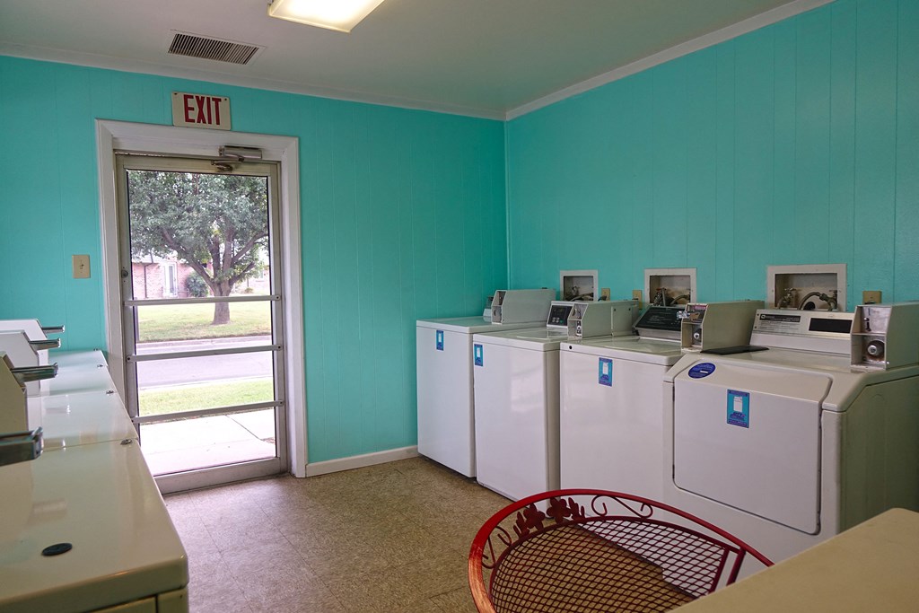 a laundry room with refrigerators and a door to an exit