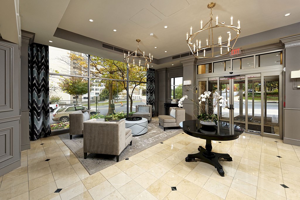 a lobby with chairs and a table and a chandelier
