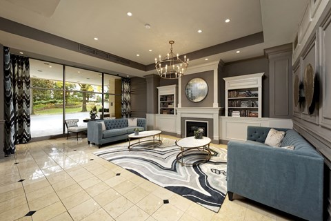 a living room with blue couches and chairs and a fireplace