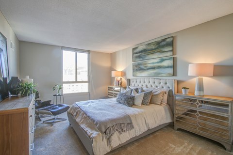 a bedroom with a bed and a dresser and a window