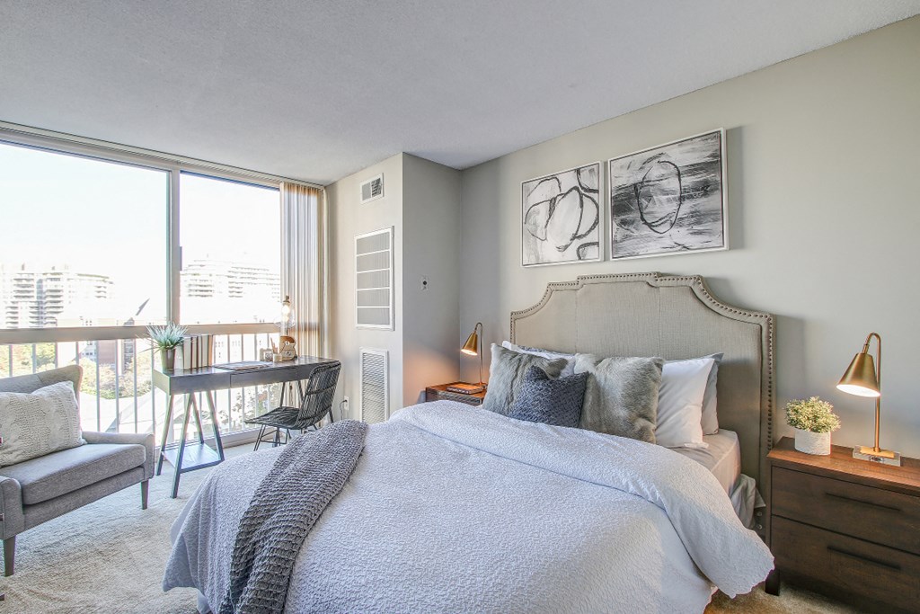 a bedroom with a bed and a desk and a window