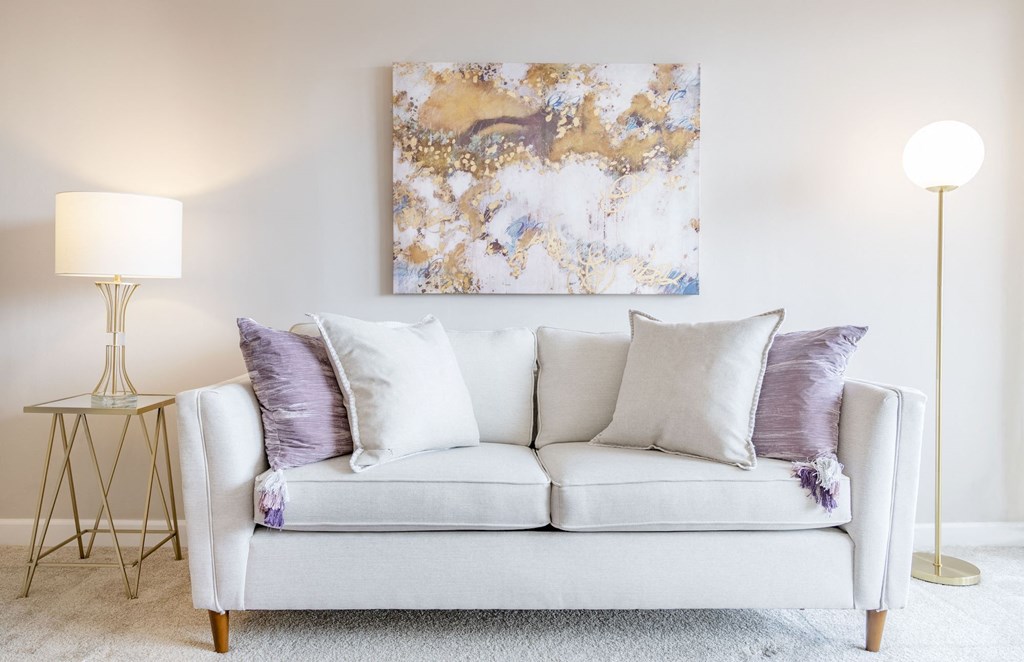 a living room with a couch and a painting on the wall