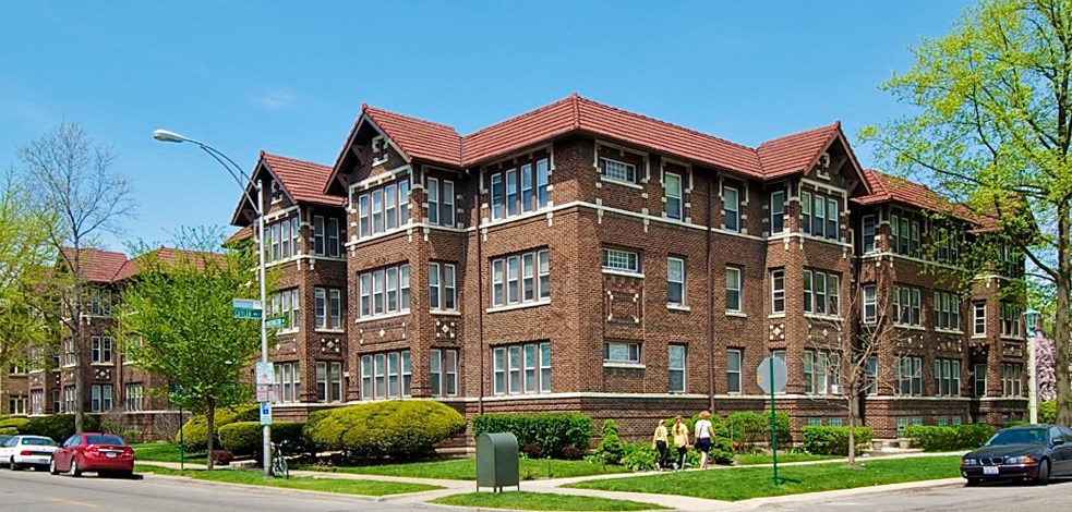 a brick apartment building on the corner of a street