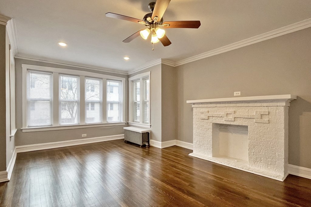 A room with a fireplace and a ceiling fan.
