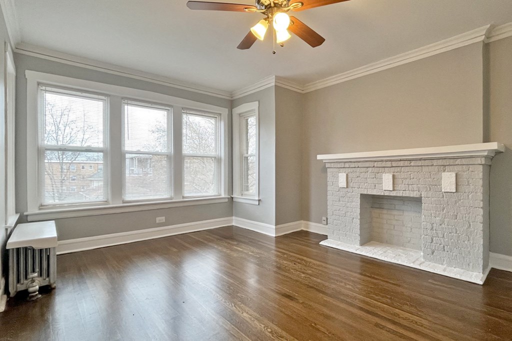 A room with a fireplace and a ceiling fan.