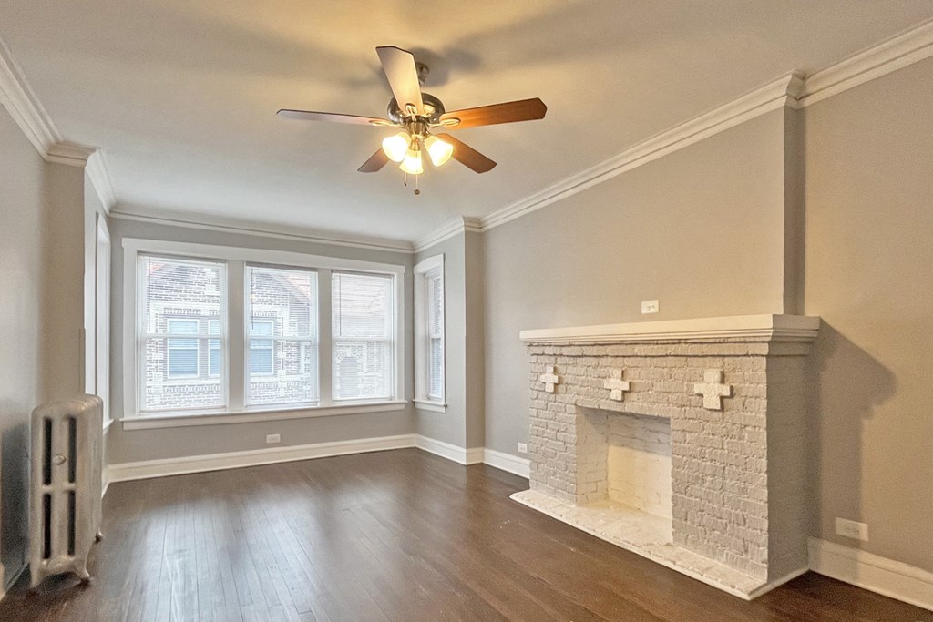 A room with a fireplace and a ceiling fan.