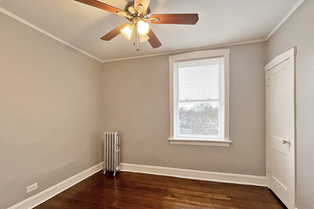 A room with a ceiling fan and a window.