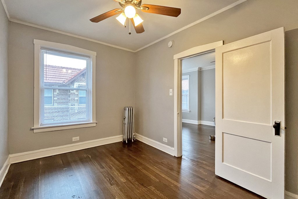 A room with a ceiling fan and a window.