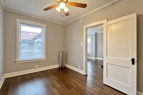 A room with a ceiling fan and a window.